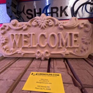 Welcome Sign with Flowers CNC carving displayed on workshop bench with ABSMolds branding