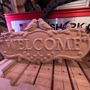 Welcome Sign with Doves CNC carving displayed on workbench after machining
